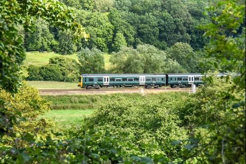 Photo of Train travelling through green landscape