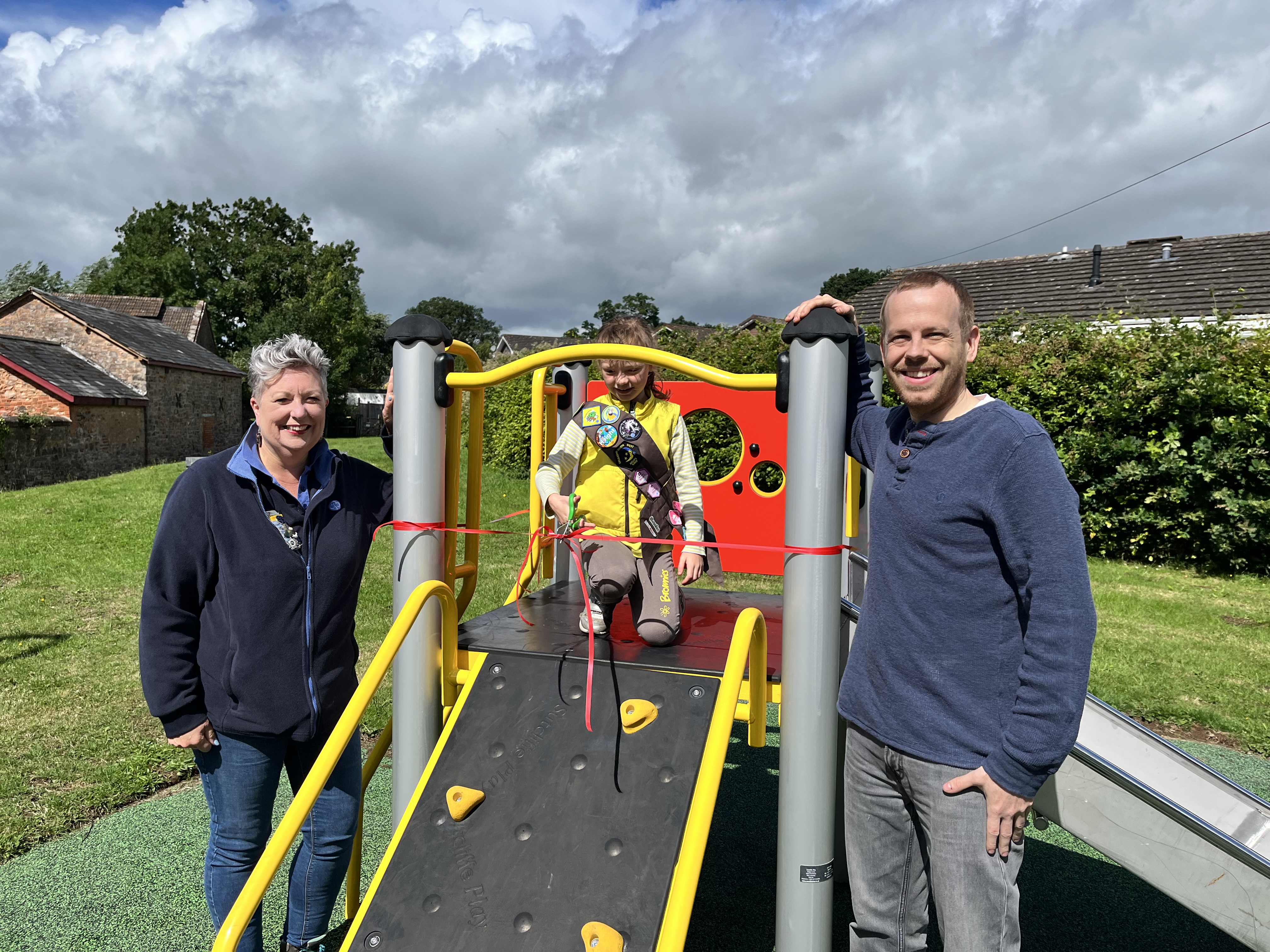 Judith Stewart (1st Willand Brownies), Seren, and Councillor Dave Wulff with the new equipment in Pippins Field Play Park, Uffculme.